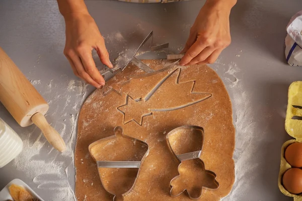 Young housewife making christmas cookies with dough cutter — Stock Photo, Image