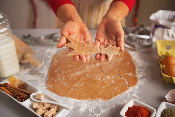 Jovem dona de casa mostrando esculpida a partir de biscoitos de Natal massa — Fotografia de Stock