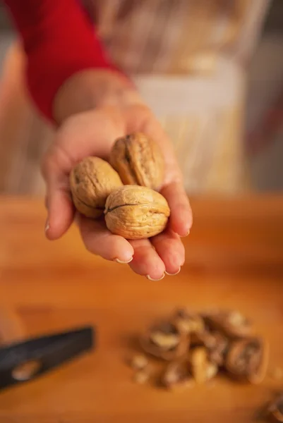 Gros plan sur jeune femme au foyer montrant des noix — Photo