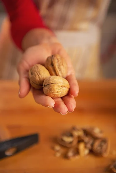 Primer plano de la joven ama de casa mostrando nueces —  Fotos de Stock