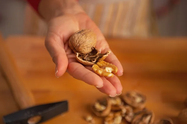 Close-up op jonge huisvrouw tonen walnoten — Stockfoto