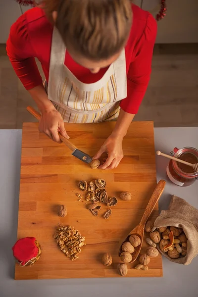 Молодая домохозяйка режет грецкие орехи — стоковое фото
