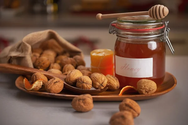 Мед и грецкие орехи на столе — стоковое фото