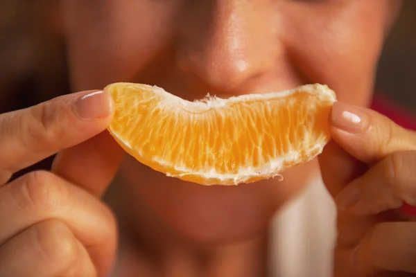 Detailní záběr na výrobu úsměv mladá žena s plátek pomeranče — Stock fotografie