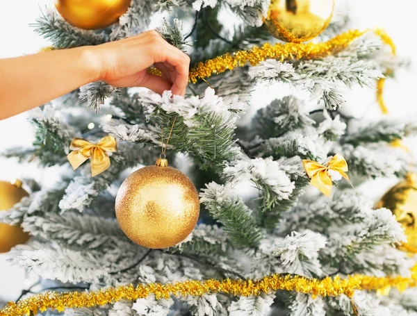 Close-up na mulher decorando árvore de Natal com bola de Natal — Fotografia de Stock