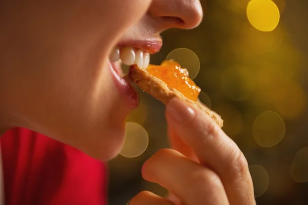 Portrét mladé ženy jíst cookie s pomerančovým džemem — Stock fotografie