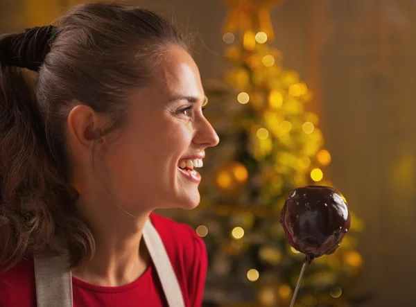 Gelukkig jonge huisvrouw appel in chocolade glazuur — Stockfoto