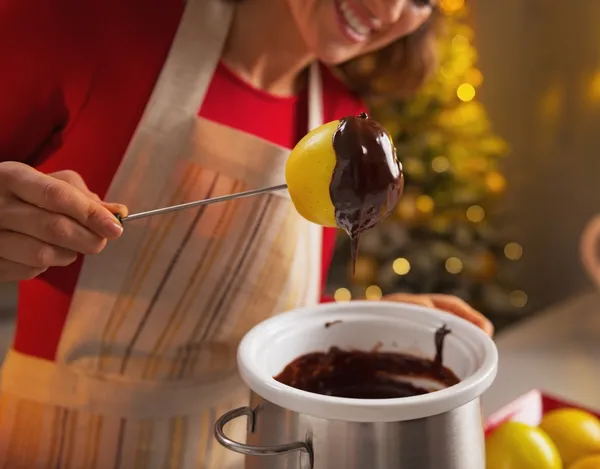 Close-up op gelukkige jonge huisvrouw maken van apple in chocolade glazuur — Stockfoto