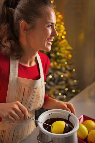 Glückliche junge Hausfrau macht Apfel in Schokoglasur — Stockfoto