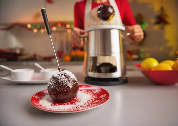 Closeup on apple in chocolate glaze and housewife in background — Stock Photo, Image