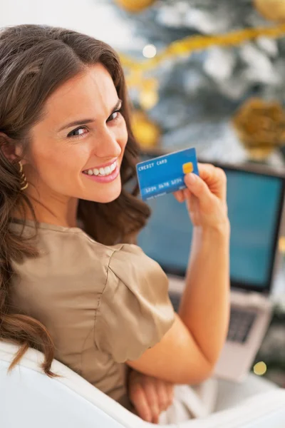 Portret van lachende jonge vrouw met creditcard via laptop — Stockfoto