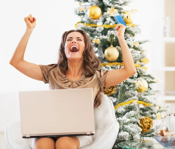 Jovem feliz com cartão de crédito e laptop regozijo — Fotografia de Stock