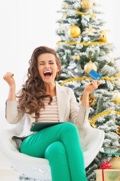 Счастливая молодая женщина с кредитной картой и планшетным компьютером радуется — стоковое фото