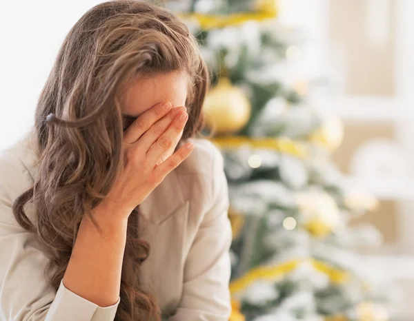 Jovem estressada na frente da árvore de Natal — Fotografia de Stock