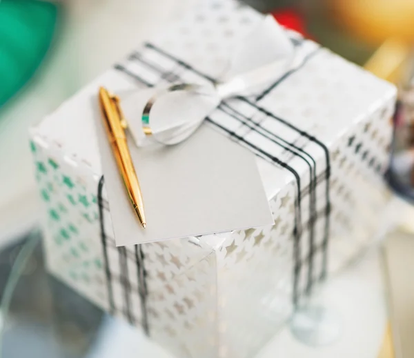 Zbliżenie na Boże Narodzenie pudełko, karta i pióra na stole — Zdjęcie stockowe