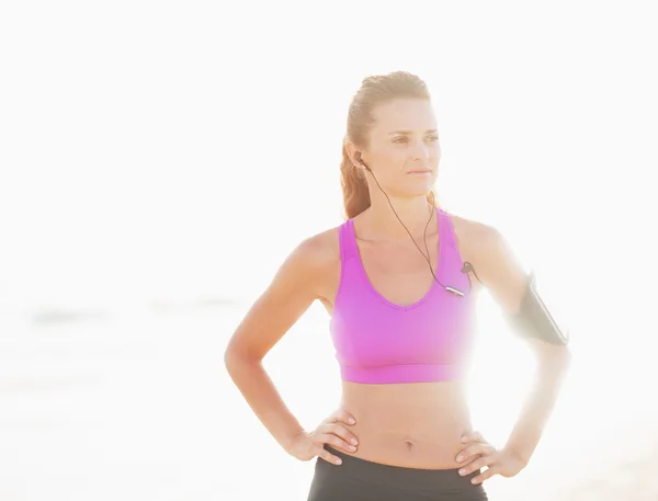 Retrato de mujer joven fitness en auriculares al aire libre en rayos o —  Fotos de Stock