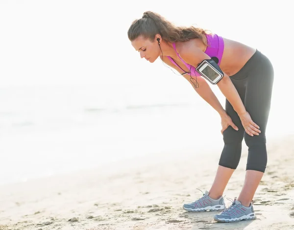 Fitness joven mujer captura respirar después de correr en la playa —  Fotos de Stock