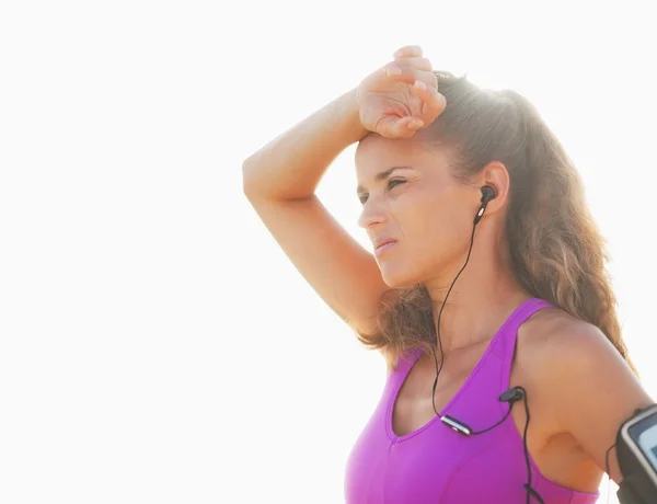 Portret van ontspannen fitness jonge vrouw in hoofdtelefoon buitenshuis — Stockfoto