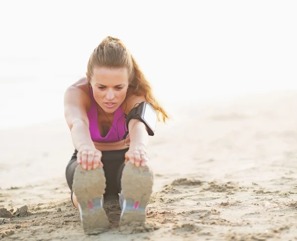 Fitness junge Frau macht Bewegung am Strand — Stockfoto