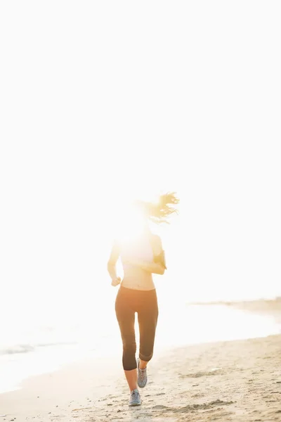 Fitness-Frau läuft am Strand — Stockfoto