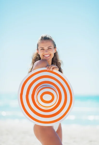 Lächelnde junge Frau im Badeanzug mit Strandhut — Stockfoto