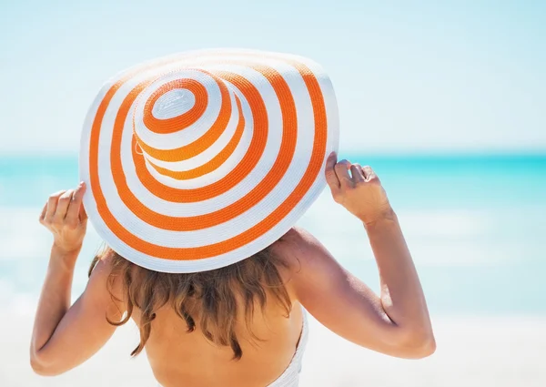 Mujer joven en traje de baño sombrero de playa mirando a la distancia —  Fotos de Stock