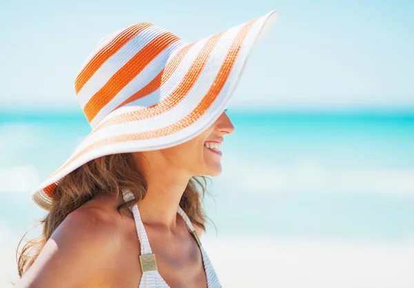Giovane donna in costume da bagno e cappello da spiaggia in cerca di spazio copia — Foto Stock