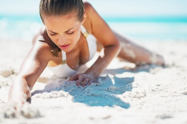 De jonge vrouw van de glamour in zwembroek opleggen strand — Stockfoto