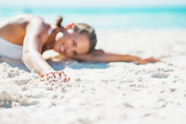 Primer plano de la mujer joven en traje de baño que pone en la playa —  Fotos de Stock
