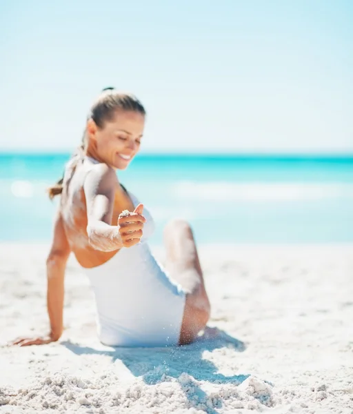 关于微笑的年轻女子坐在海滩上的泳装特写 — 图库照片