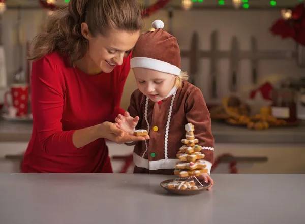 Happy mother and baby making christmas tree from cookies — Stock Photo, Image