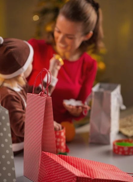 Різдвяні сумки для покупок, мати і дитина на задньому плані — стокове фото