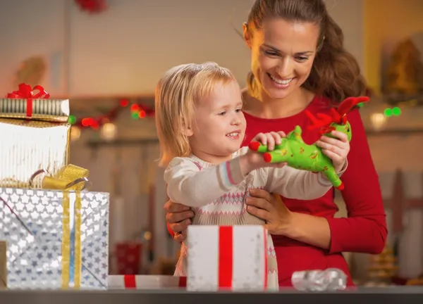 Счастливая мама и ребенок открывают рождественские подарки — стоковое фото
