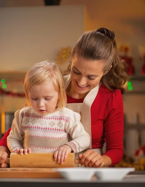Anne ve bebek Noel süslenmiş mutfakta PIN hamuru haddeleme