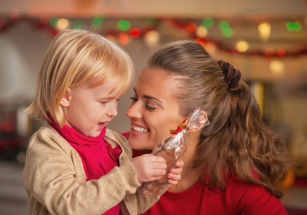 Portret szczęśliwy matki i dziecka z czekolady santa — Zdjęcie stockowe