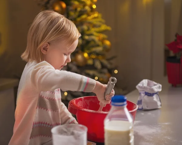 Baby kneading dough in christmas decorated kitchen — Stock Photo, Image
