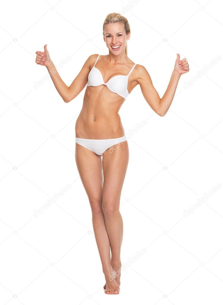 Full length portrait of happy young woman in lingerie showing thumbs up