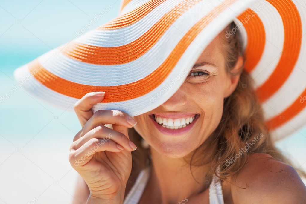 Portrait of happy young woman in swimsuit and beach hat