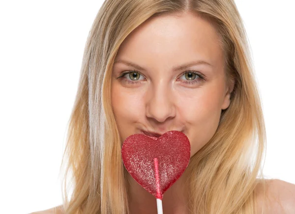 Portrait of young woman with heart shaped lollipop — Stock Photo, Image