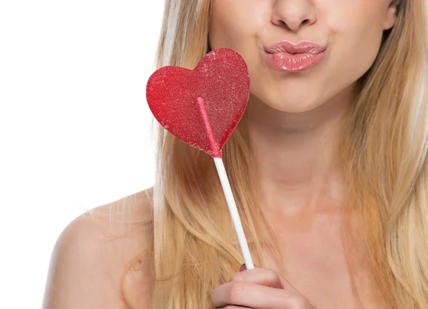 Close-up op doordachte jonge vrouw met hartvormige lolly — Stockfoto