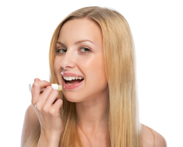 Jonge vrouw met behulp van hygiënische lippenstift — Stockfoto