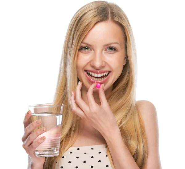 Feliz joven mujer comiendo píldora — Foto de Stock