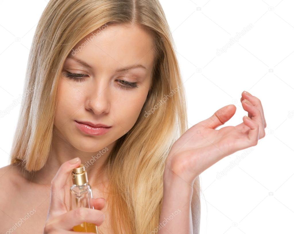 Young woman applying perfume on hand