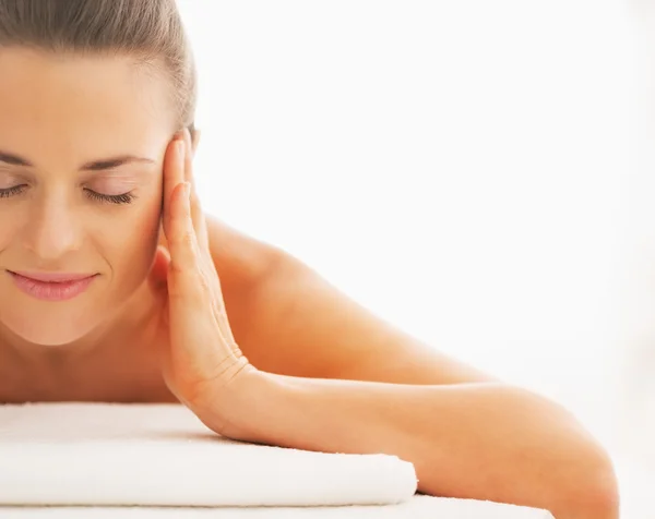 Relaxed young woman laying on massage table — Stock Photo, Image