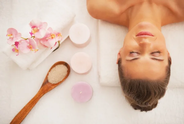 Retrato de mujer joven acostada sobre mesa de masaje lista para terapia de spa —  Fotos de Stock
