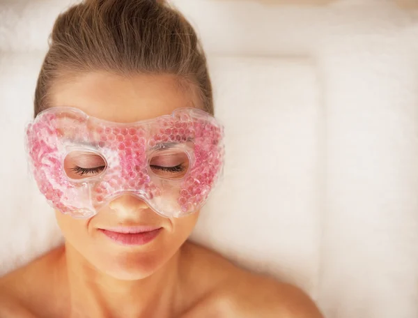 Portrait of young woman in eye mask laying on massage table — Stock Photo, Image