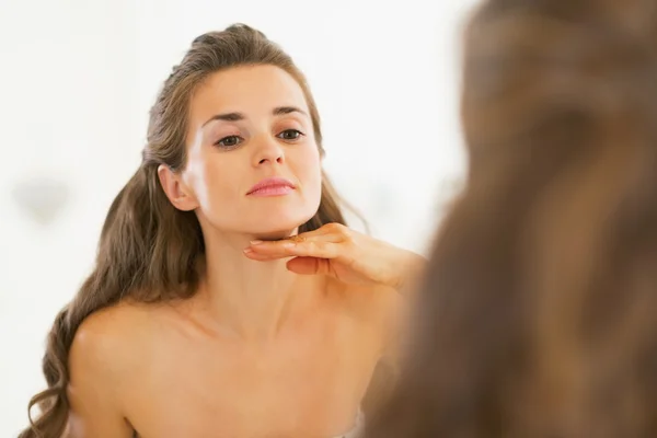 Jeune femme examinant l'état de peau faciale — Photo