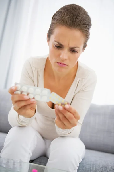Young woman choosing pills — Stock Photo, Image