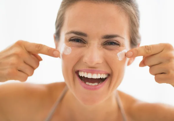 Mujer joven feliz divertirse mientras se aplica la crema en el baño —  Fotos de Stock