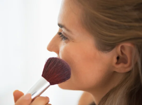 Mujer joven aplicando maquillaje —  Fotos de Stock